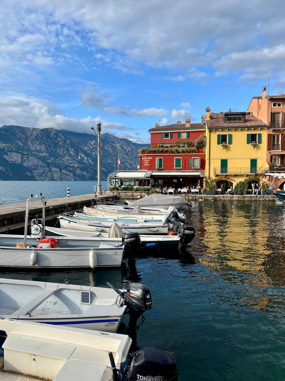colorful italian lakefront with boats and mountains